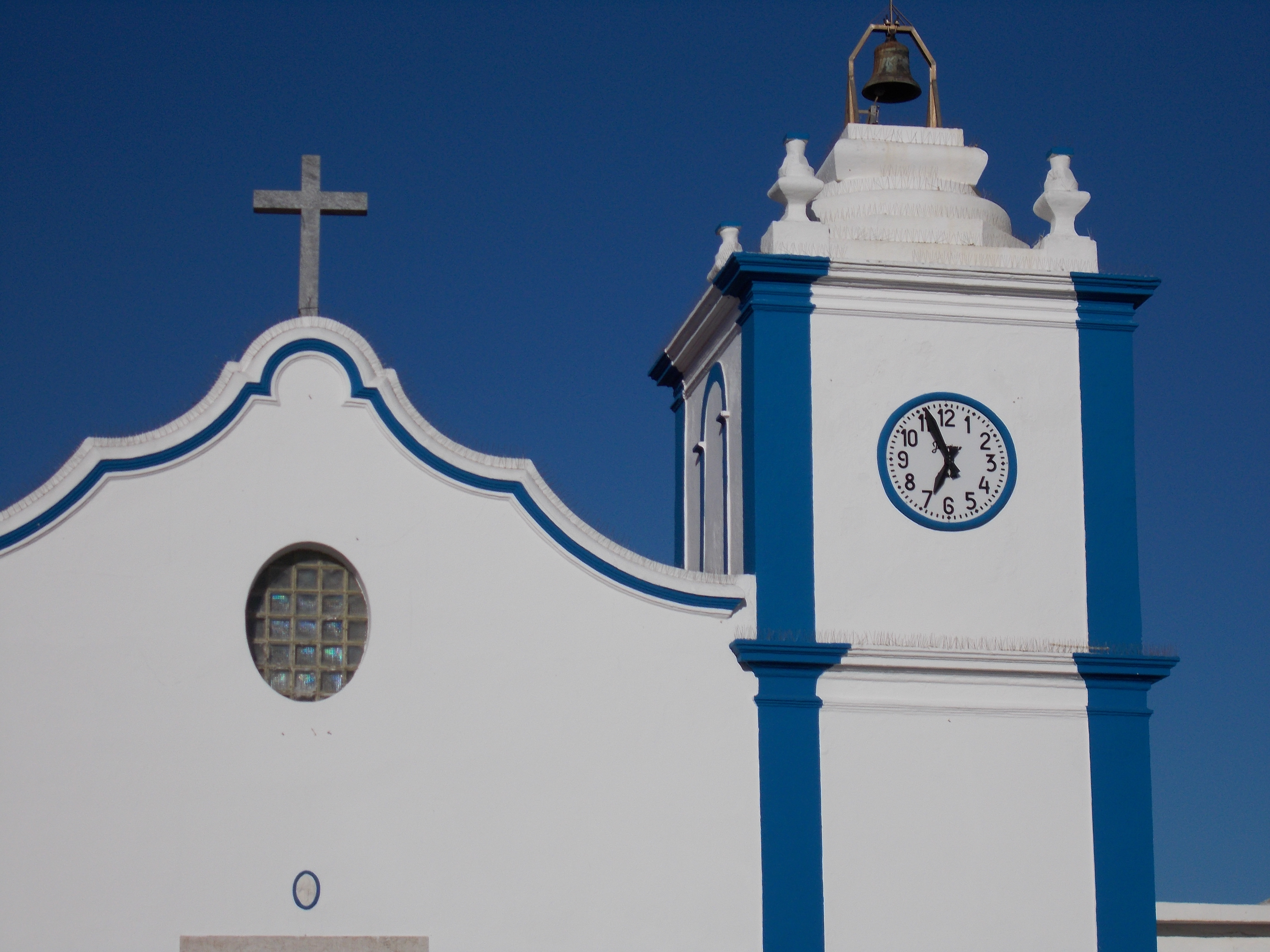 Pormenor da torre sineira e da empena da fachada principal.