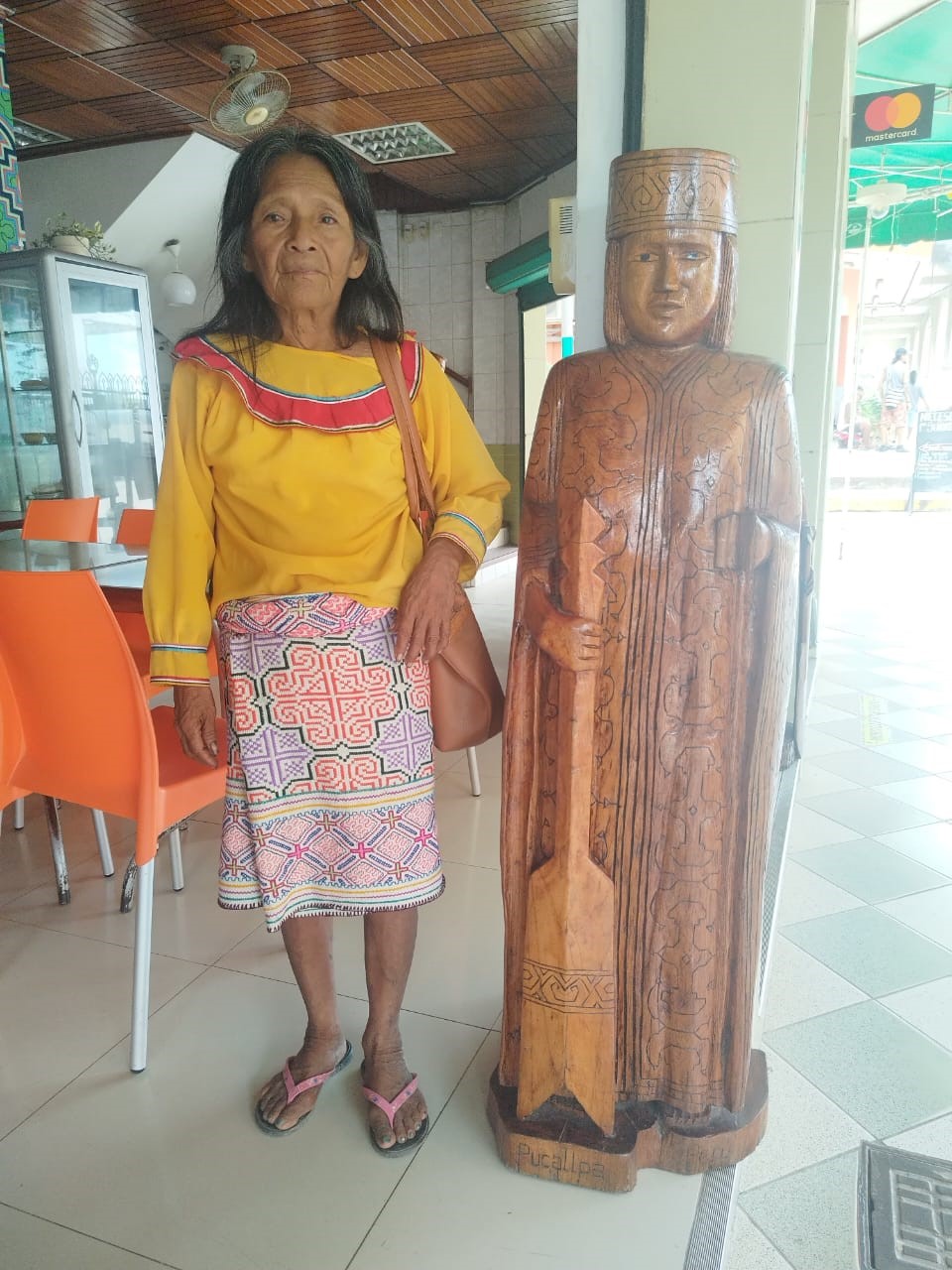 Elisia, near a statue of a Shipibo person